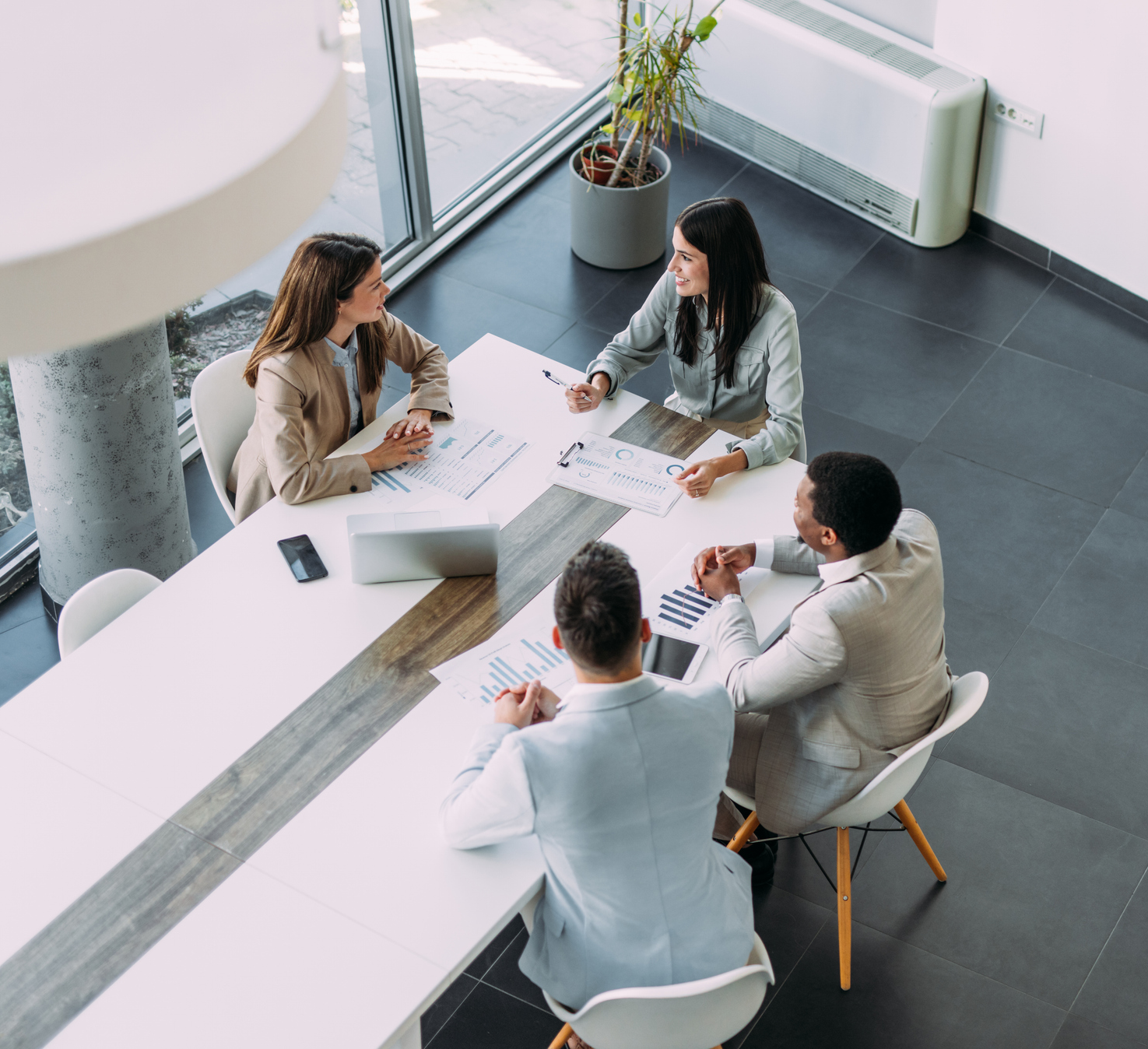 Business meeting with four people at table.