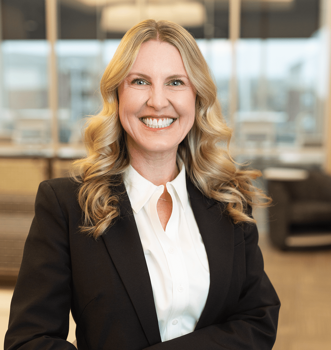 Smiling woman in business attire, office background.